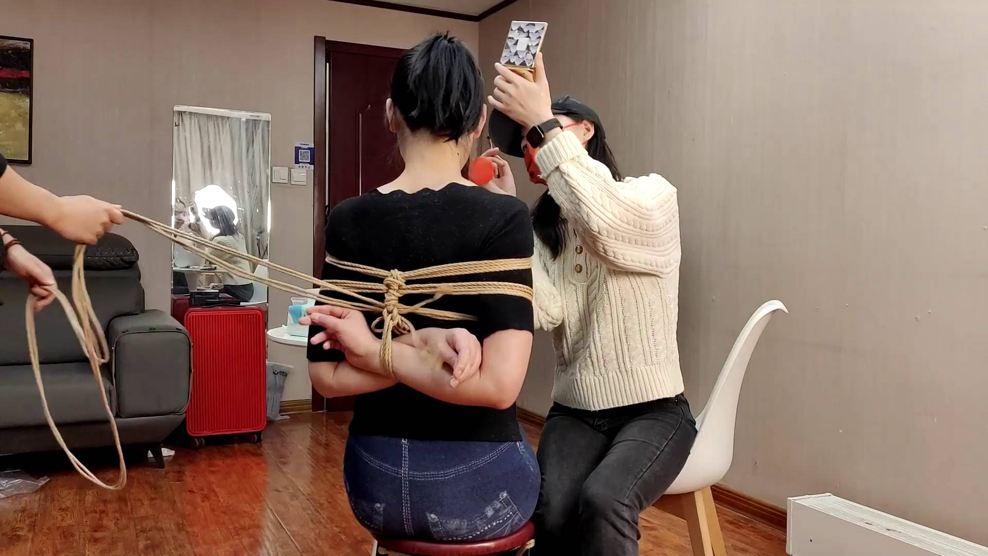 女孩一边捆绑一边化妆