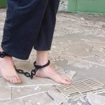 戴着脚镣在废墟里光脚和穿白袜散步